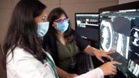 Radiologist and resident look at images